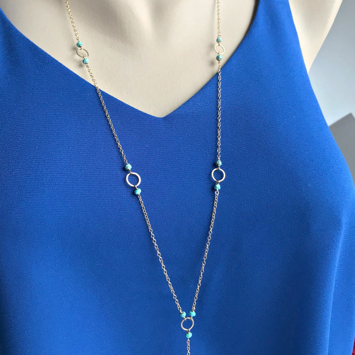 Close-up of the top part of a necklace, highlighting the arrangement of the links and turquoise beads