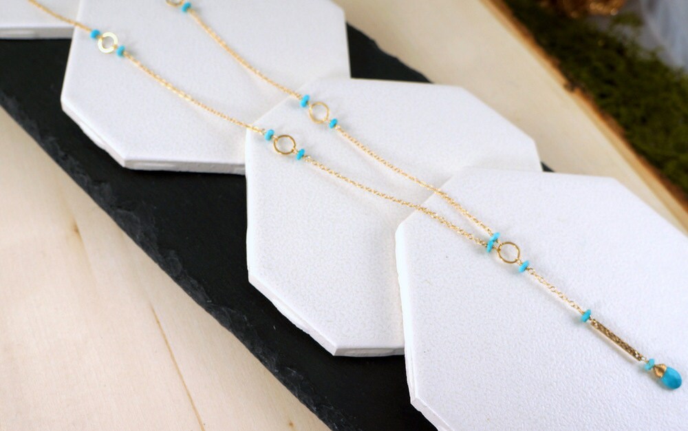 Close-up view of a turquoise Y-bar necklace laid flat, showing the pendant and chain details